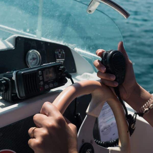 Woman,Sailing,,With,Hands,Holding,Steering,Wheel,And,Radio,Of