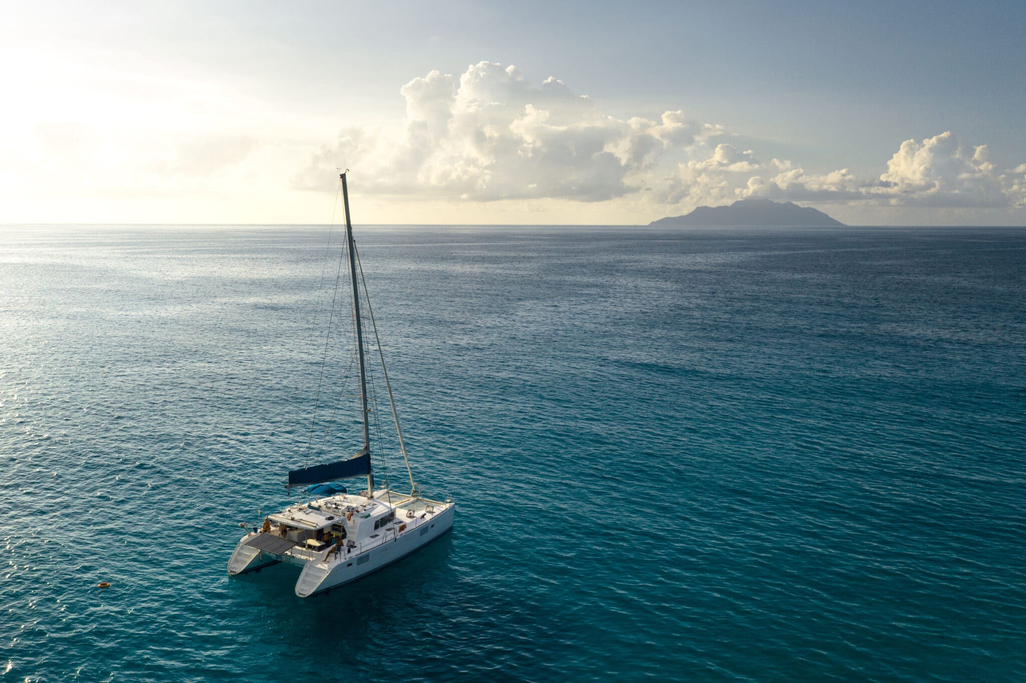 Eco,Yacht,Catamaran,Sailing,In,Ocean,At,Sunset.,Aerial,View